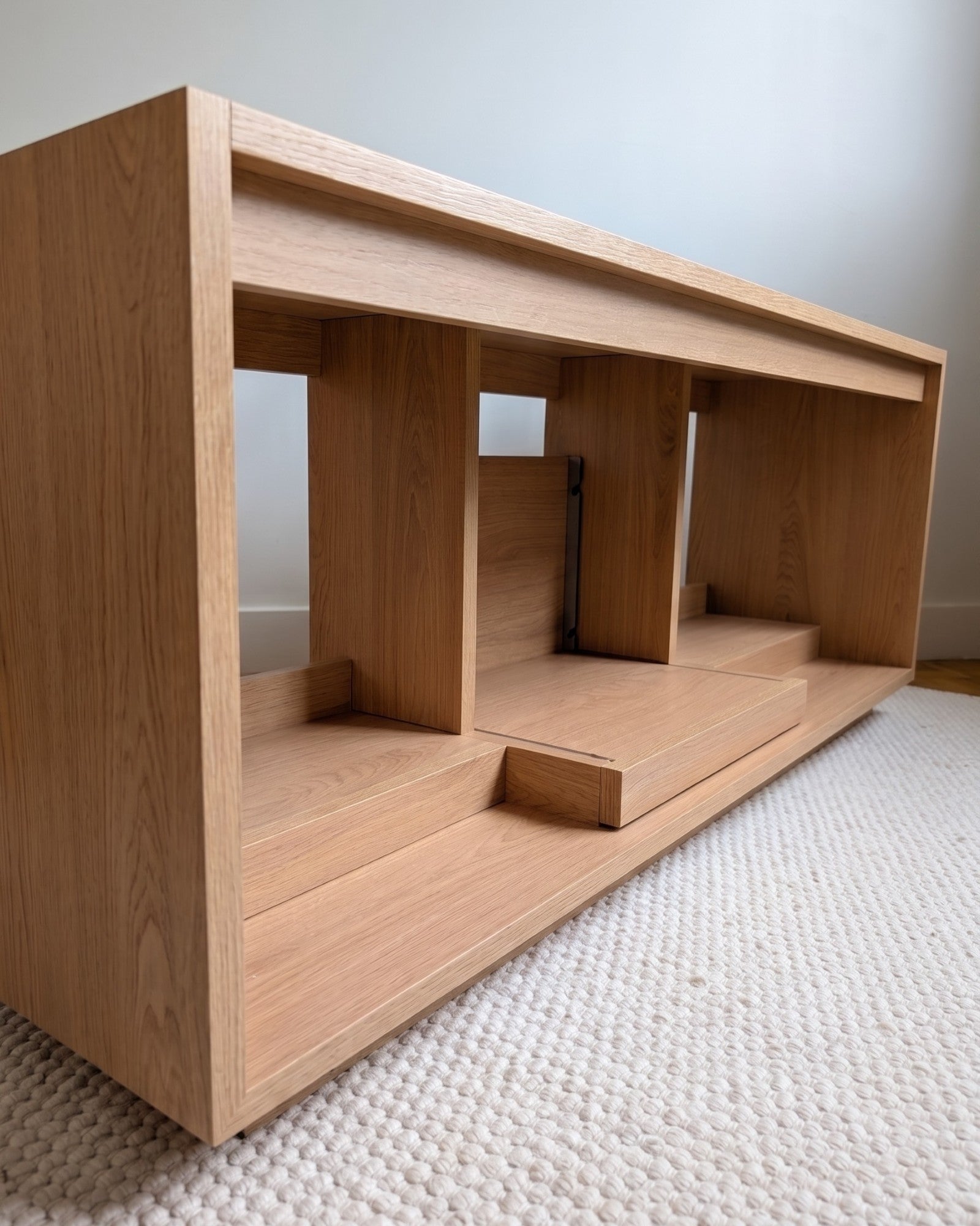 Empty Bloom Console in a Corbridge oak finish at a three-quarter angle, showing central compartment and bays — Groovaly
