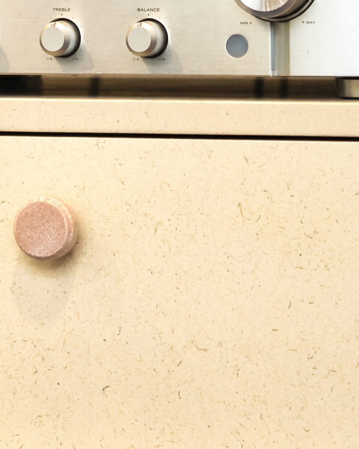 Front view of a White Pearl drawer, wood-fibre flecks visible across the matt surface, below a hi-fi amplifier — Groovaly