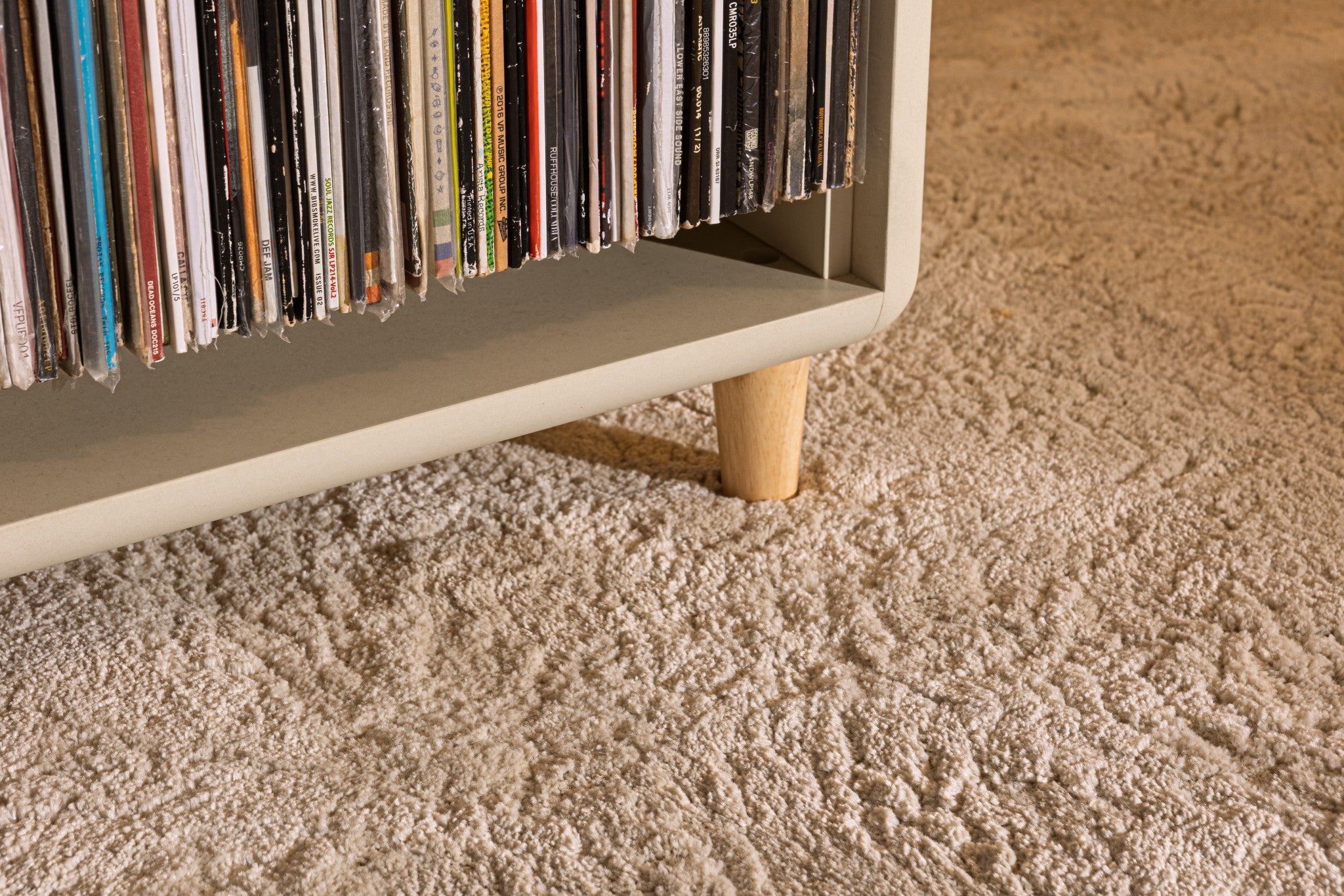 Close view of a wooden foot under a White Pearl module full of records — Groovaly