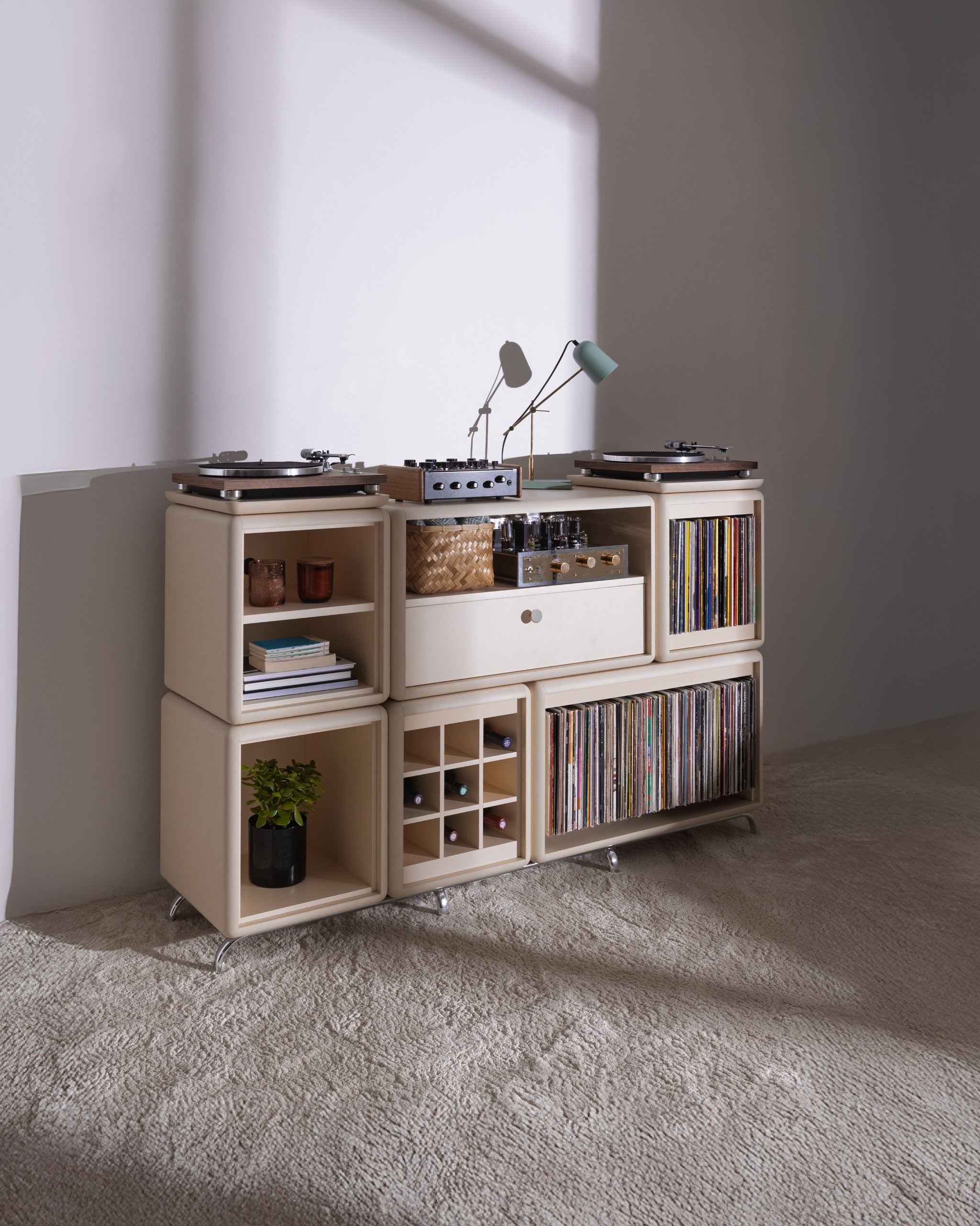 Wilson in White Pearl in a room, full of records with a turntable on top and bottles in the Grid — Groovaly