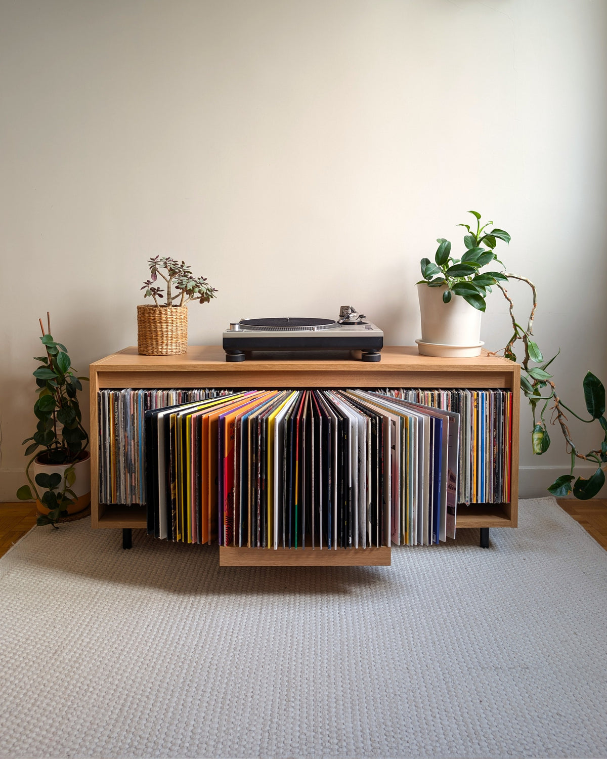 A single Bloom Console with a Corbridge oak finish, records fanned open in the Bloom drawer, turntable on top — Groovaly