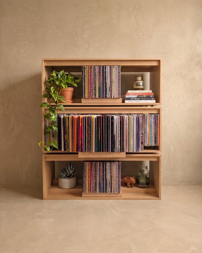Three Bloom Consoles stacked in a Corbridge oak finish forming a record wall, side bays holding plants — Groovaly