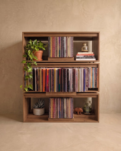 Three Bloom Consoles stacked in a walnut finish forming a record wall, side bays holding plants — Groovaly