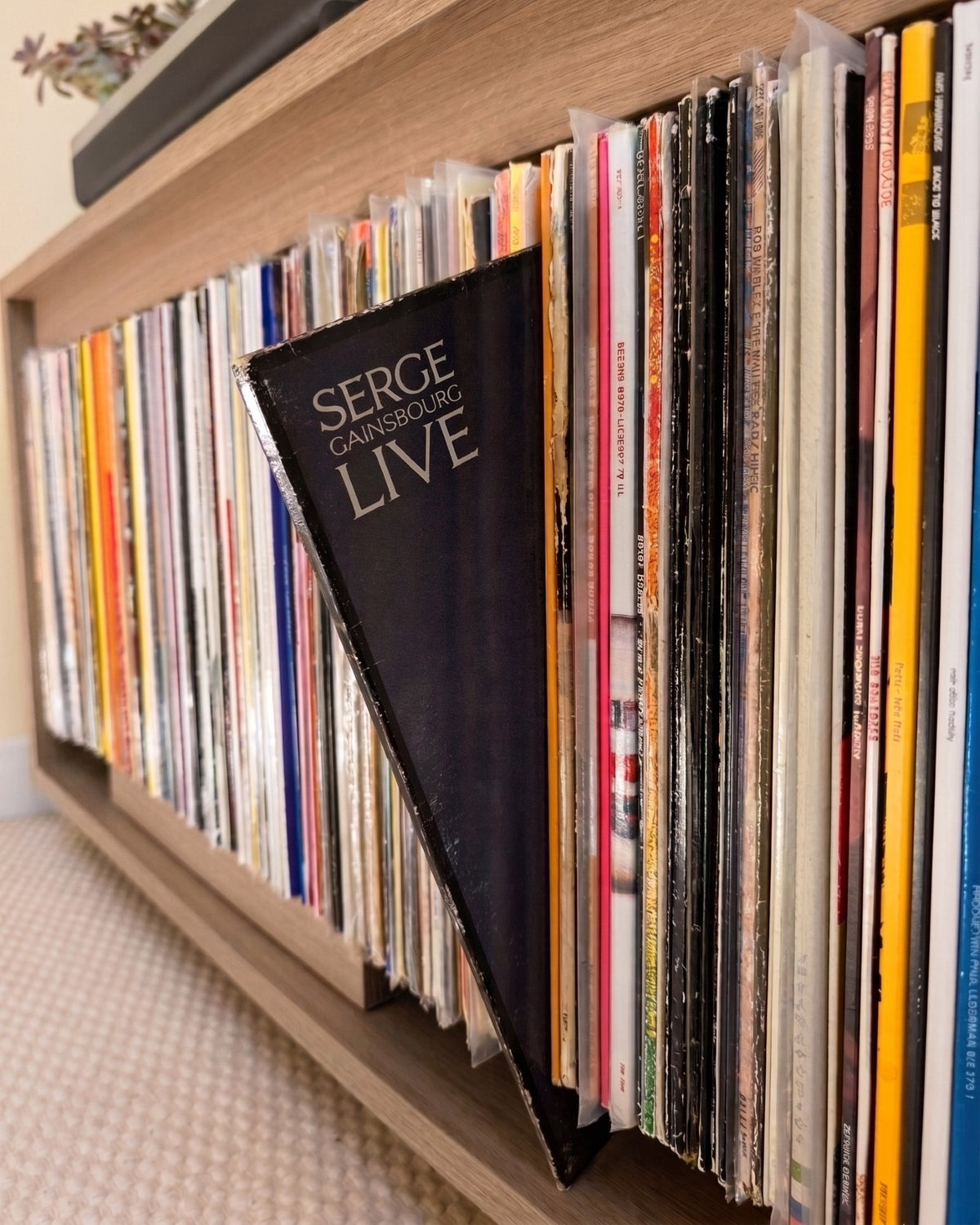 A sleeve tilted forward in a side bay of Bloom Console, cover shown in place, in a Corbridge oak finish — Groovaly
