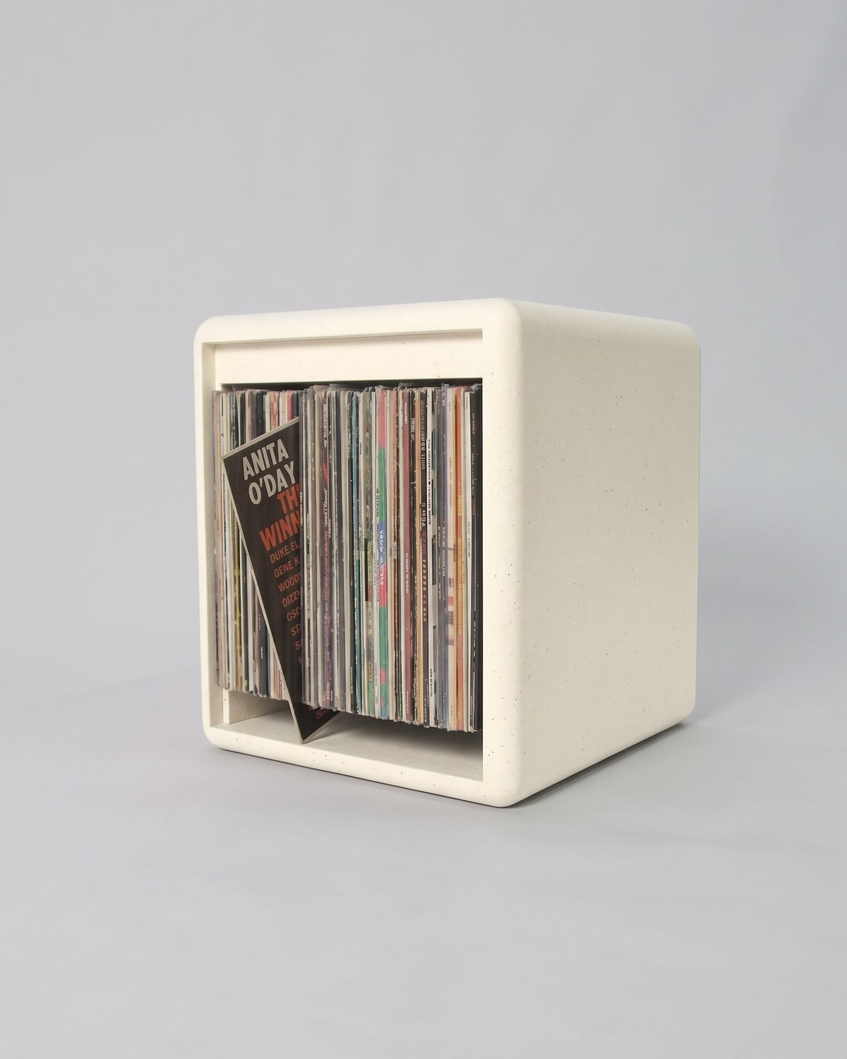 Lean module in White Pearl Valchromat, three-quarter view, filled with records with one tipped forward on its rear base to show its cover — Groovaly