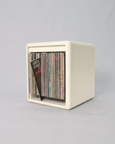 Lean module in White Pearl Valchromat, three-quarter view, filled with records with one tipped forward on its rear base to show its cover — Groovaly