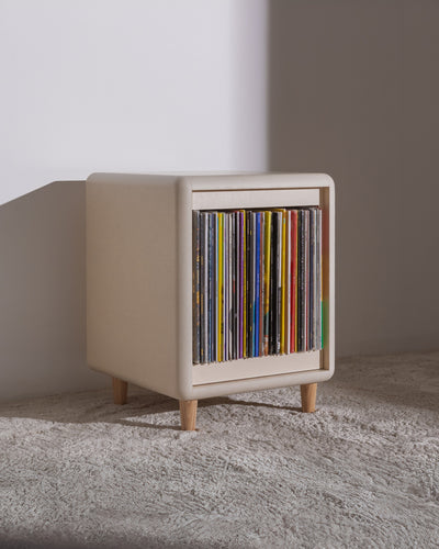 Otis vinyl furniture in White Pearl on wooden feet, filled with records, three-quarter view — Groovaly