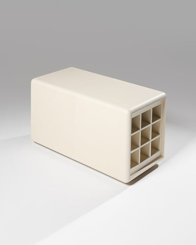 Tina in White Pearl in studio, the nine-bottle Grid beside the closed Bloom drawer — Groovaly